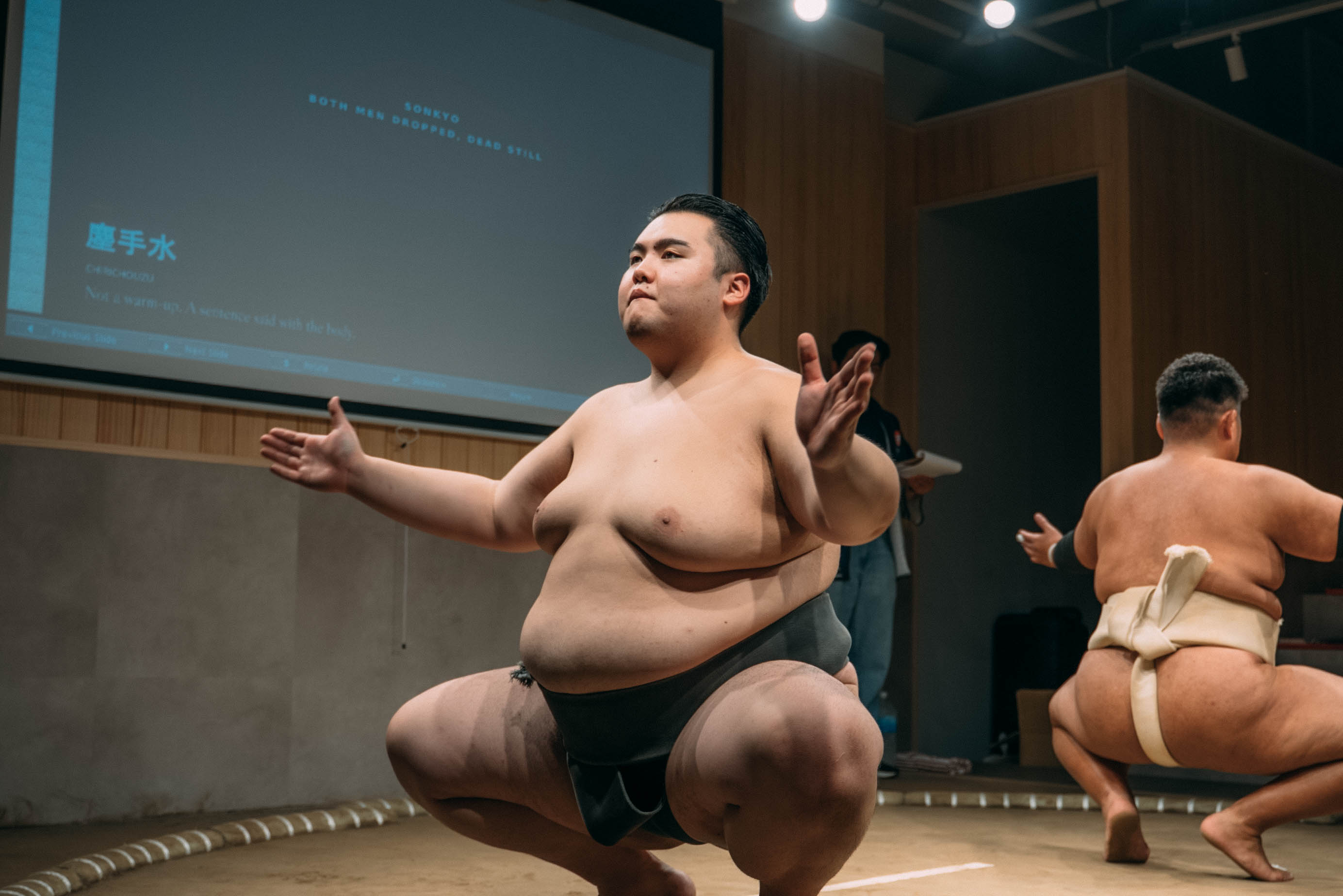 Sumo wrestler performing the sonkyo squat and chiri-chozu purification ritual